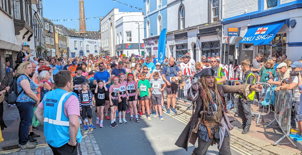 Runners dressed in Pirate outfits at the start of the Pirates Fun Run on The Barbican in Plymouth